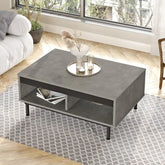 Table basse DIONE en gris effet béton ciré avec pieds acier noir, vue en situation dans un salon moderne.